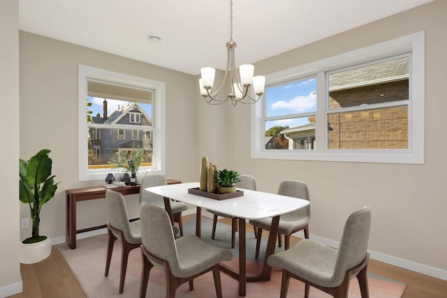 dining area featuring hardwood / wood-style floors and an inviting chandelier