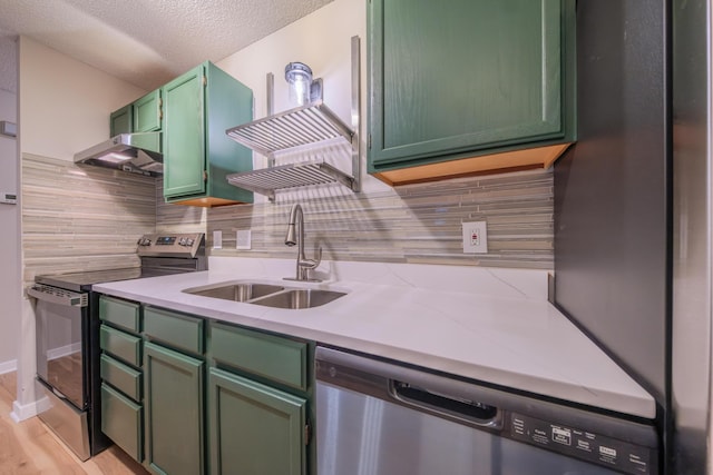 kitchen with sink, stainless steel appliances, green cabinets, ventilation hood, and a textured ceiling