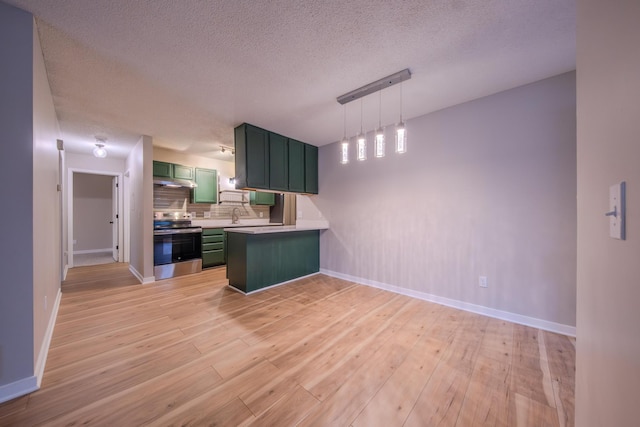 kitchen featuring green cabinets, hanging light fixtures, decorative backsplash, light wood-type flooring, and stainless steel electric range oven