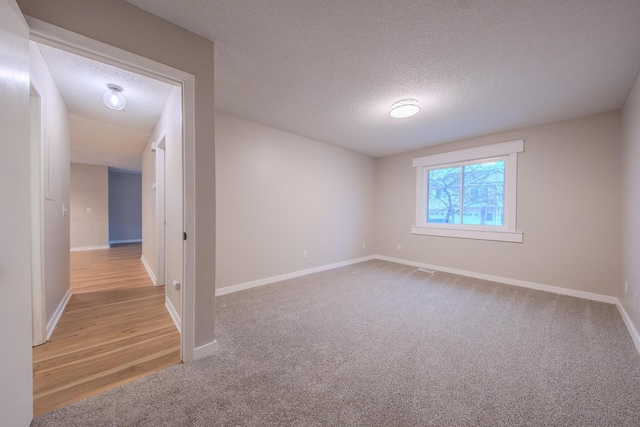 carpeted spare room with a textured ceiling