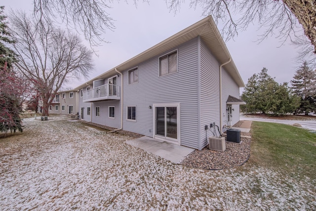 rear view of house featuring a patio, a balcony, cooling unit, and a lawn