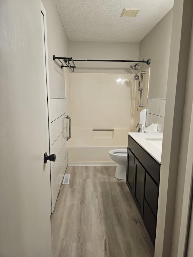 bathroom featuring hardwood / wood-style floors, vanity, a textured ceiling, and toilet