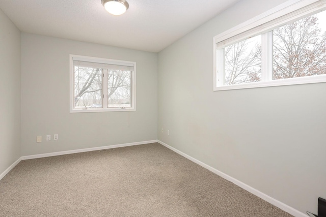 carpeted spare room with baseboards