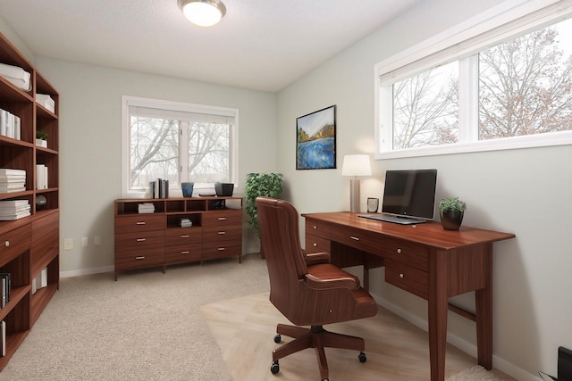 home office featuring light carpet and baseboards