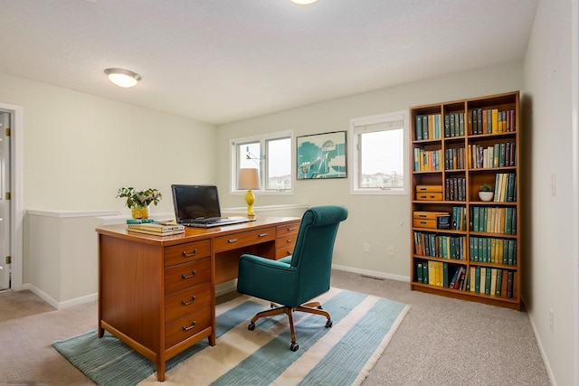 office space with baseboards and light colored carpet