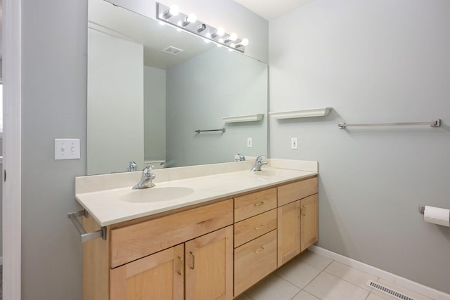 bathroom with double vanity, visible vents, a sink, and tile patterned floors