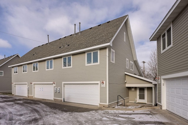 back of property with a shingled roof