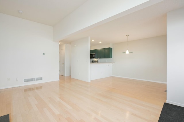 unfurnished living room featuring recessed lighting, light wood-type flooring, visible vents, and baseboards