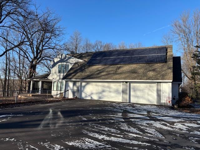 view of front of home featuring a garage and solar panels