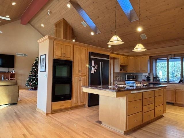 kitchen with a center island, black appliances, a skylight, beam ceiling, and light hardwood / wood-style floors