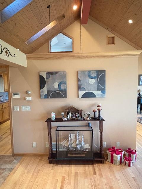 details featuring beam ceiling, wood-type flooring, wood ceiling, and a skylight