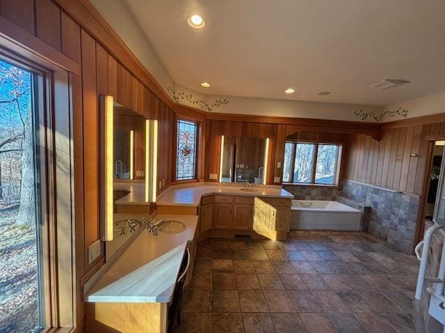 kitchen with kitchen peninsula, sink, and wooden walls