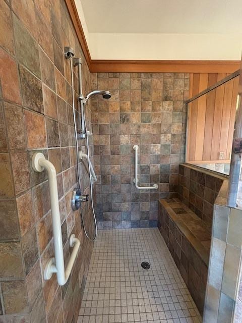 bathroom with tiled shower and tile patterned flooring