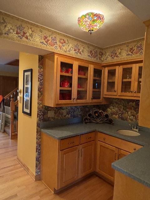11233 Chisago Blvd, Chisago City, MN 55013 - kitchen featuring light wood-style flooring, decorative backsplash, glass insert cabinets, and a textured ceiling
