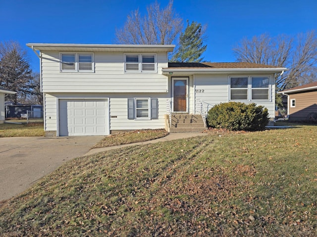 tri-level home featuring a garage and a front lawn