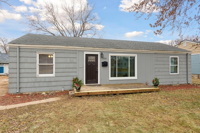 ranch-style home with a wooden deck and a front yard