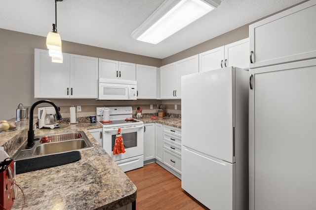 kitchen with white cabinetry, sink, white appliances, and decorative light fixtures