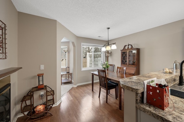 dining space with wood-type flooring and a textured ceiling