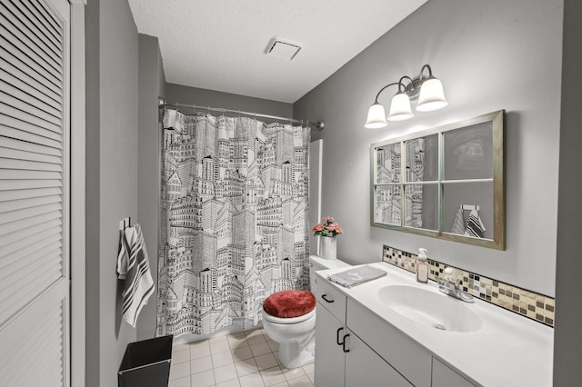 bathroom with tasteful backsplash, tile patterned flooring, vanity, toilet, and a textured ceiling