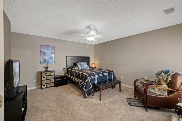 bedroom featuring ceiling fan, light carpet, and a textured ceiling