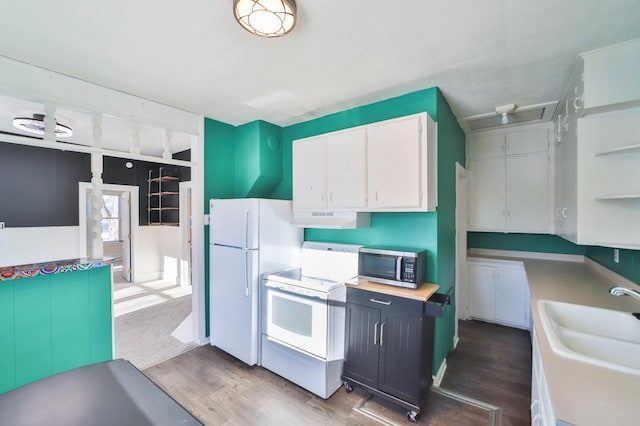 kitchen with dark hardwood / wood-style floors, stove, white cabinetry, and range hood