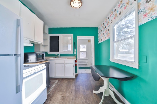 kitchen featuring white cabinetry, sink, light hardwood / wood-style flooring, range hood, and white appliances