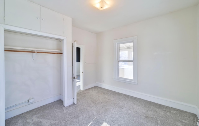 unfurnished bedroom with light carpet and a closet