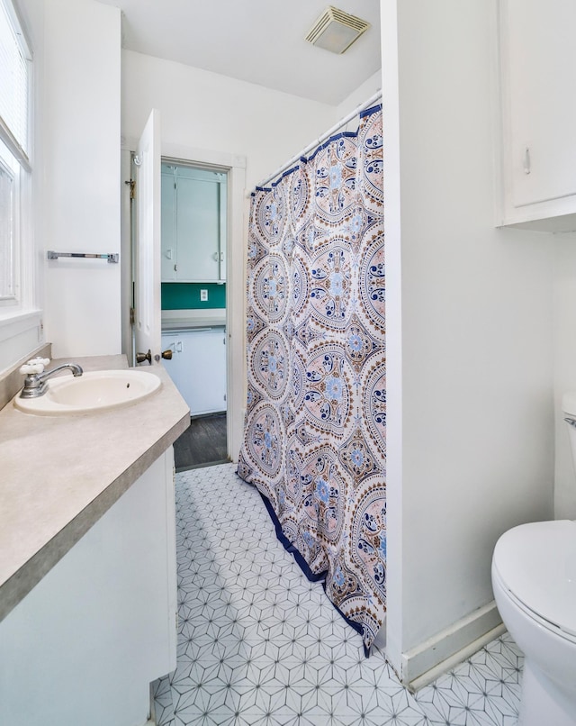 bathroom with tile patterned flooring, vanity, and toilet