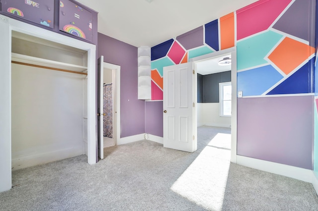 unfurnished bedroom featuring light colored carpet and a closet