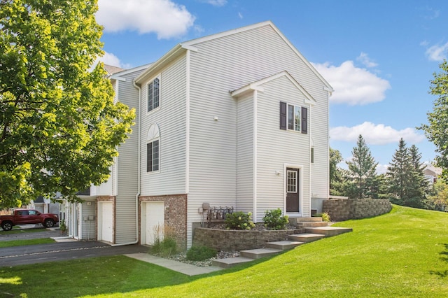 view of side of home featuring a yard and a garage