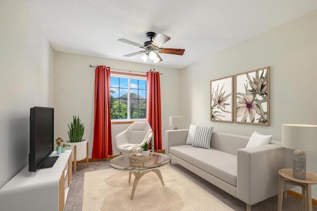 carpeted living room featuring ceiling fan and a textured ceiling