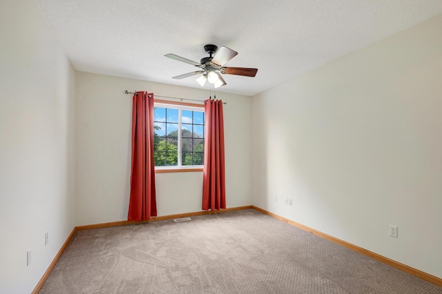 carpeted spare room with a textured ceiling and ceiling fan