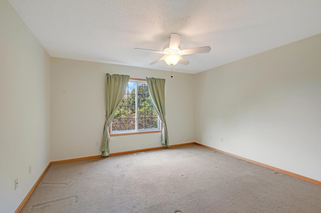 empty room featuring a textured ceiling, carpet floors, and ceiling fan