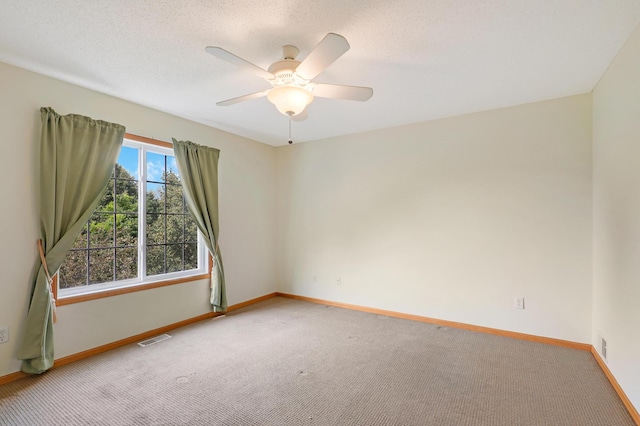 carpeted empty room with ceiling fan and a textured ceiling