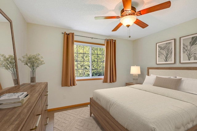 bedroom with carpet flooring, ceiling fan, and a textured ceiling