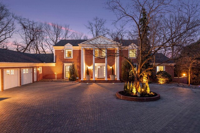 2496 Old Beach Rd, Orono, MN 55391 - greek revival house with decorative driveway, a garage, and brick siding