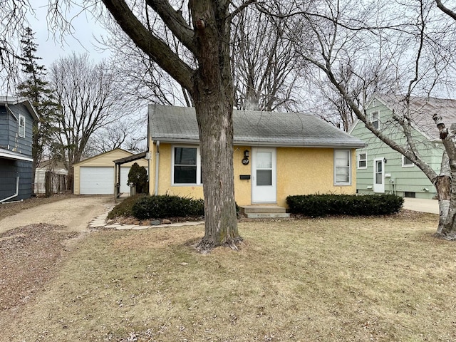 view of front facade featuring an outbuilding, a garage, and a front lawn