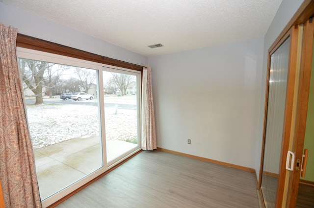 entryway with hardwood / wood-style floors and a textured ceiling