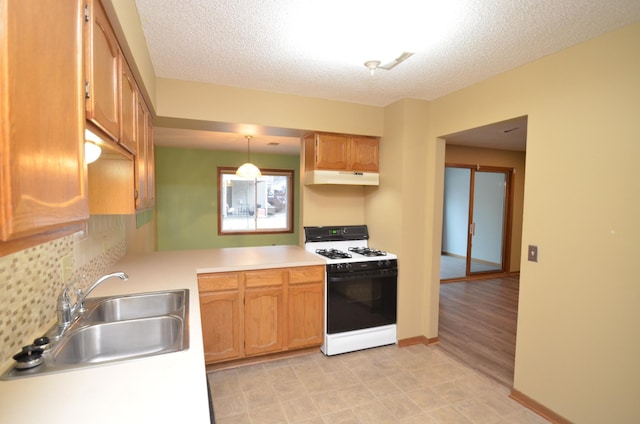 kitchen with sink, hanging light fixtures, light hardwood / wood-style floors, a textured ceiling, and white gas range oven