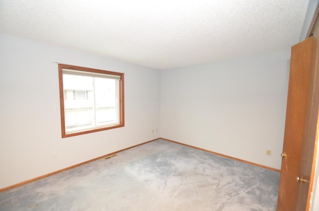 spare room featuring carpet and a textured ceiling