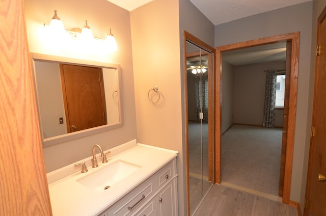 bathroom with hardwood / wood-style flooring, vanity, and ceiling fan