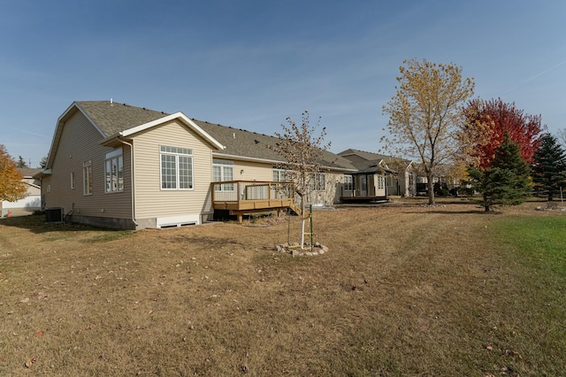 rear view of property with a yard, cooling unit, and a deck