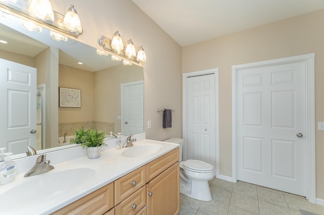 bathroom featuring tile patterned floors, vanity, a bathtub, and toilet