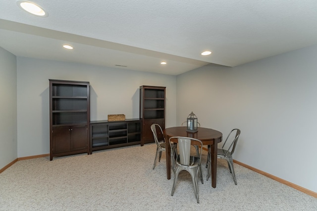 dining area featuring carpet floors and a textured ceiling