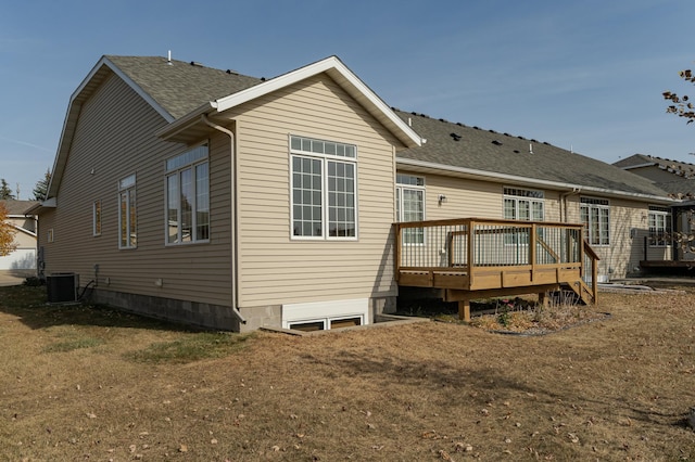 back of property with a lawn, central AC unit, and a deck