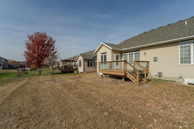 rear view of house with a yard and a wooden deck