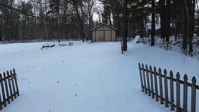 snowy yard with a storage shed