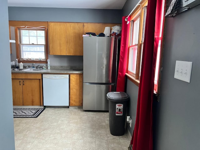 11159 Steamboat Loop NW, Walker, MN 56484 - kitchen with dishwasher, freestanding refrigerator, brown cabinetry, and light flooring