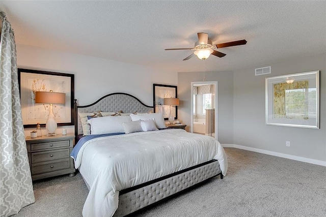 bedroom featuring a textured ceiling, ceiling fan, light carpet, and ensuite bath