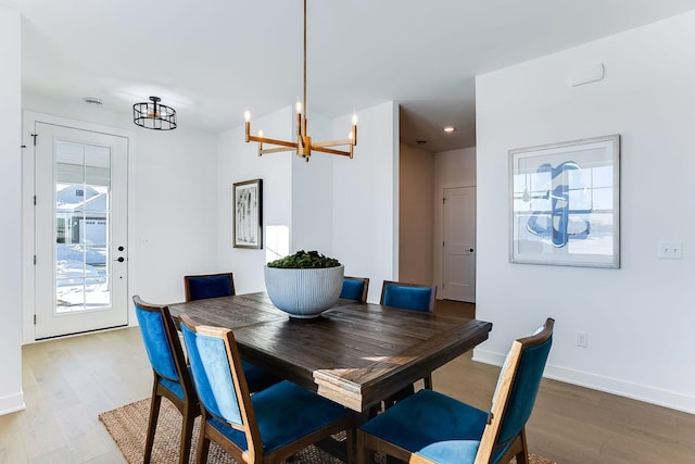 dining space featuring an inviting chandelier and light hardwood / wood-style flooring